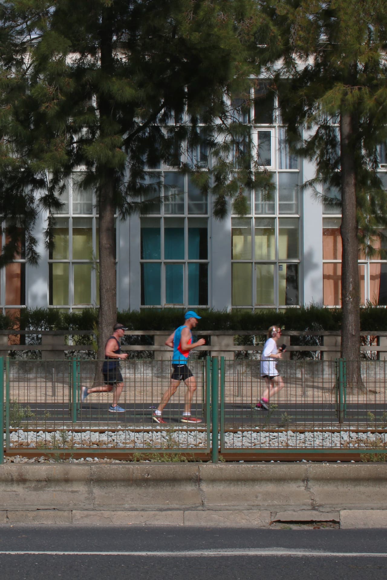 Tres personas corriendo junto a una infraestructura urbana en Lisboa.