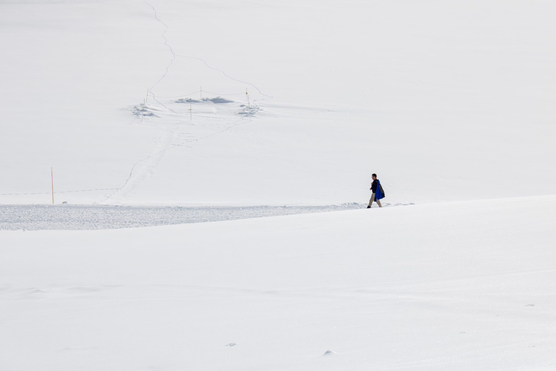 Figura humana caminando sobre una extensa llanura nevada.